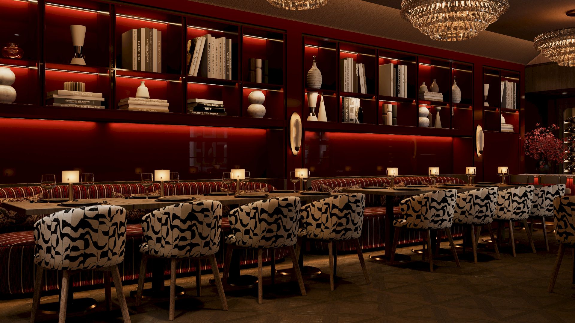 The image shows a dimly lit bar with elegant chandeliers, plush patterned seating, and shelves displaying decorative items and books.